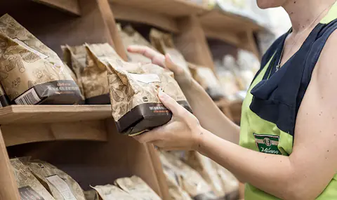 Addetta MAMO che consiglia una cliente tra gli scaffali gluten free